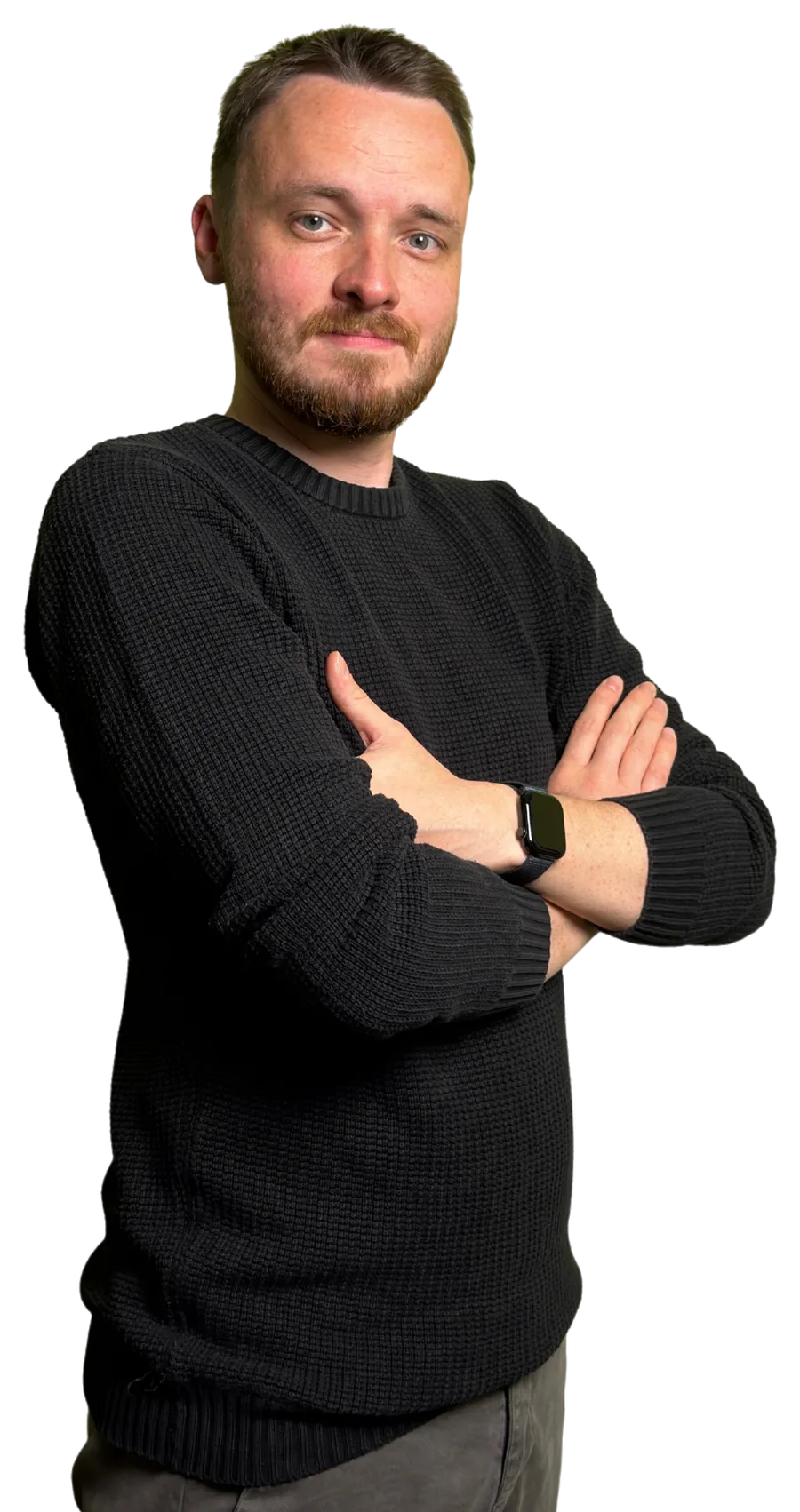 Anthony in a black jumper, standing with his arms folded and a confident smile