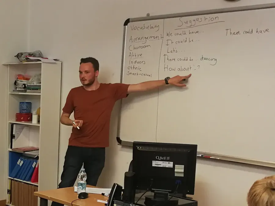 Anthony at a whiteboard, pointing at phrases for making suggestions